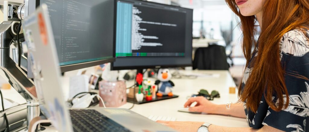 woman in green shirt sitting in front of computer