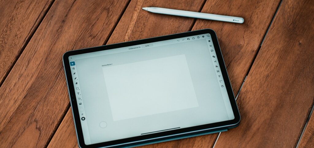 black ipad on brown wooden table