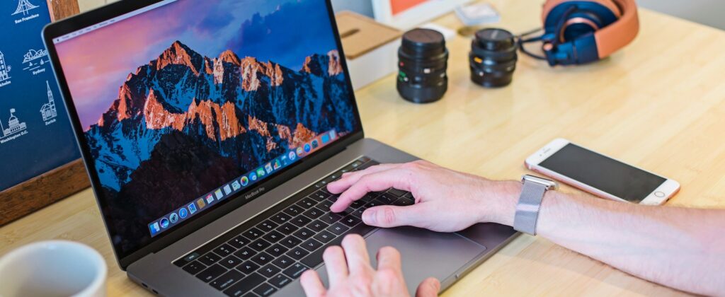 MacBook Pro turned on beside white ceramic mug