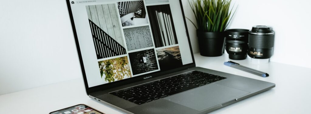 silver laptop computer beside black smartphon